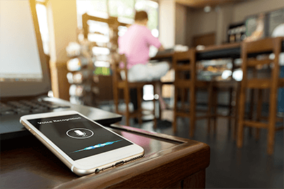 phone with voice recognition enabled, person at table in background