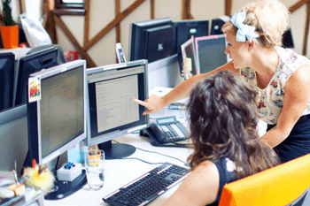 people in office, discussing content on computer screen