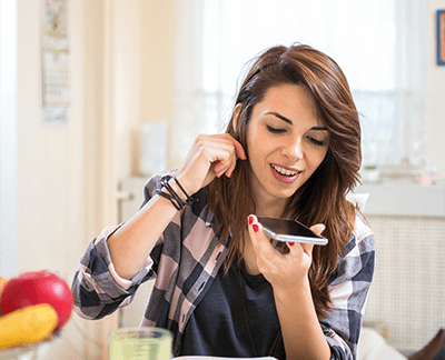 woman at table speaking into phone