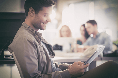 person smiling while looking at a tablet