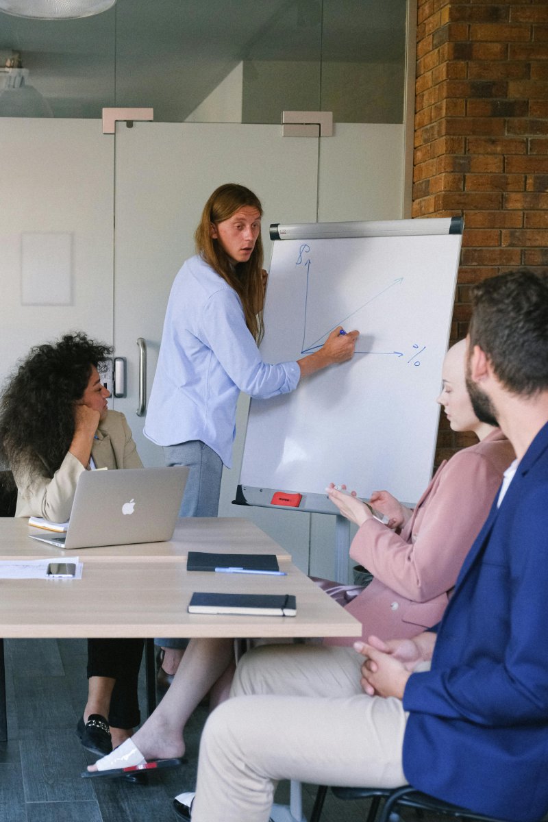 Senior digital strategist presenting an SEO and content roadmap on a large screen to business stakeholders in a conference room